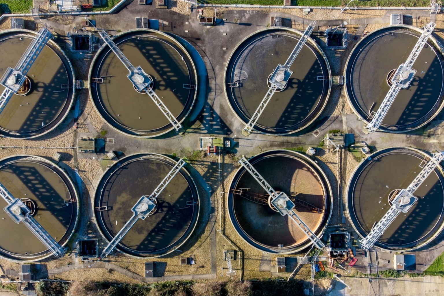 Aerial view of circular clarifier basins at a water treatment plant in daylight
